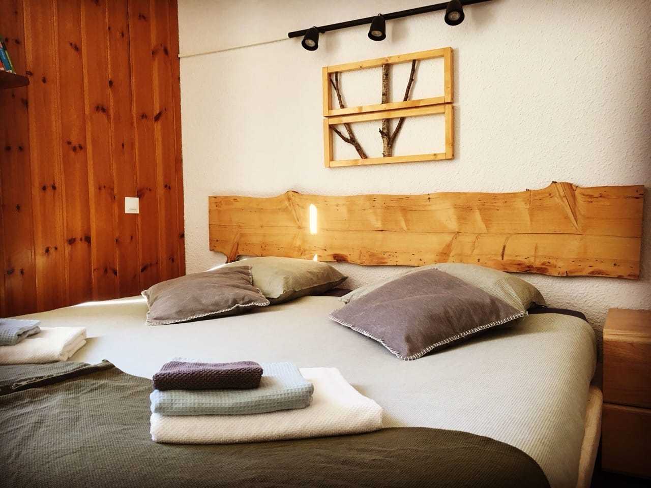 Bedroom at Hotel Au Bon Accueil Les Deux Alpes with wood accents, off-white walls, and cozy furnishings