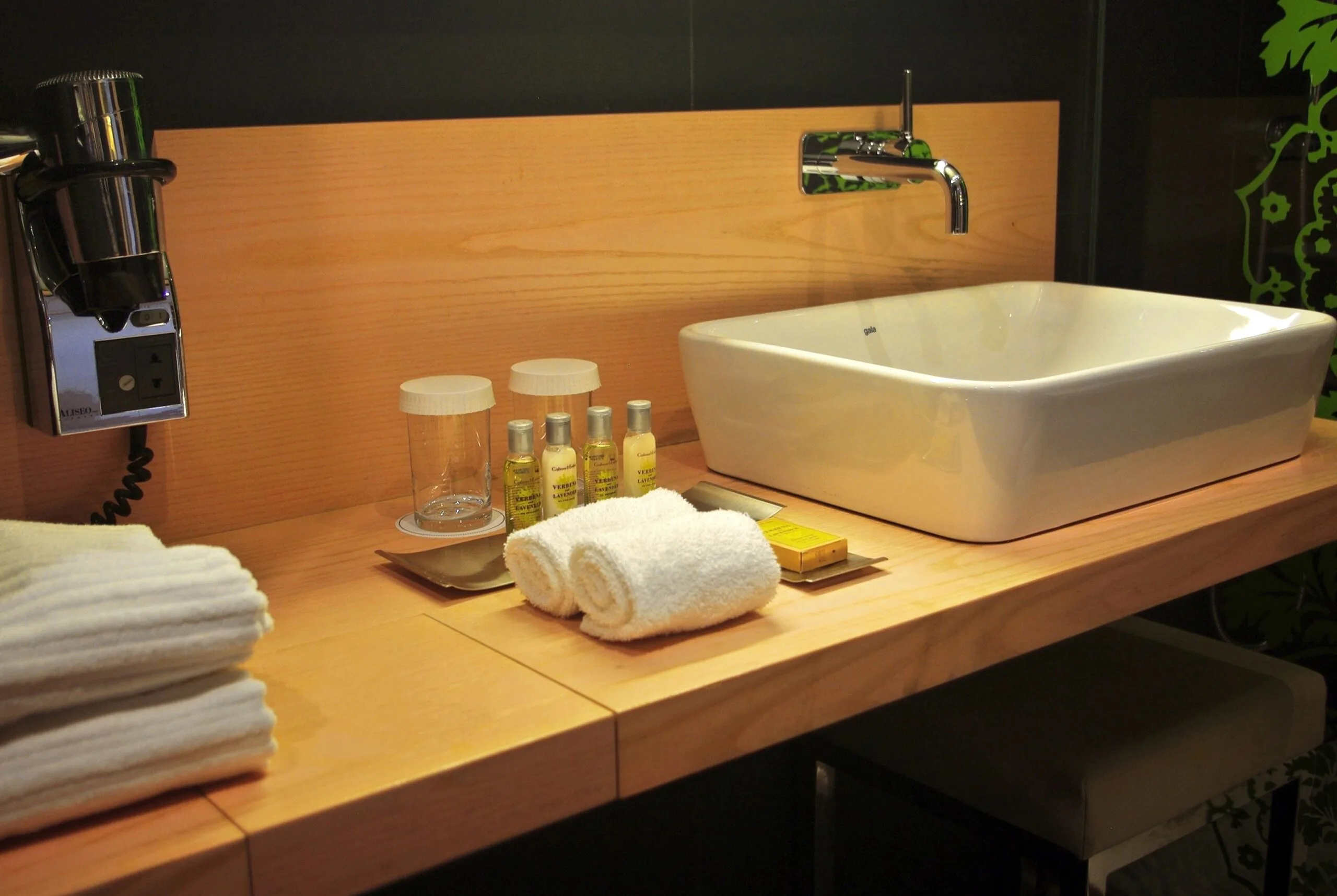 Wooden sink unit with white sink and bath essentials at DoubleTree by Hilton Girona in a modern bathroom