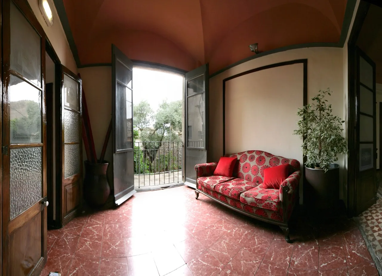 Spacious living room at Casa Cundaro in Girona with a single sofa near a large two-door entrance