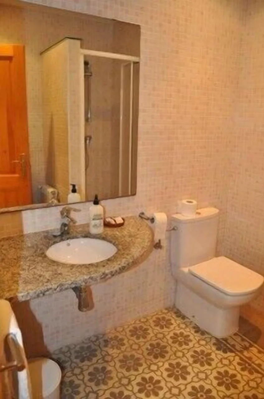 Bathroom at Casa Cundaro in Girona with traditional decor, featuring tiled walls and classic fixtures