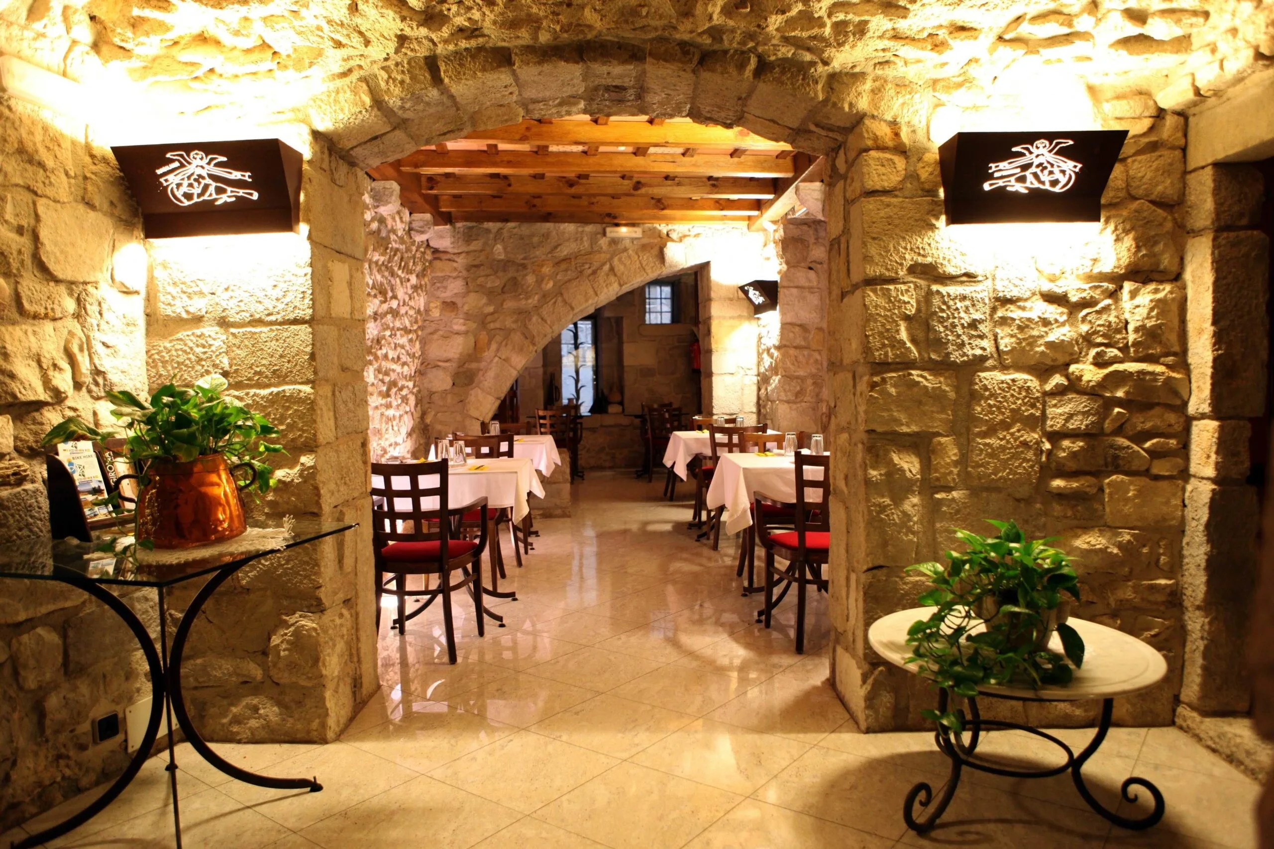 Restaurant at Hotel Històric in Girona featuring stone architecture, warm lighting, and an inviting ambiance