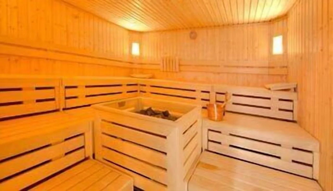 Sauna at Hotel Rezia with full wooden design featuring warm lighting and bench seating