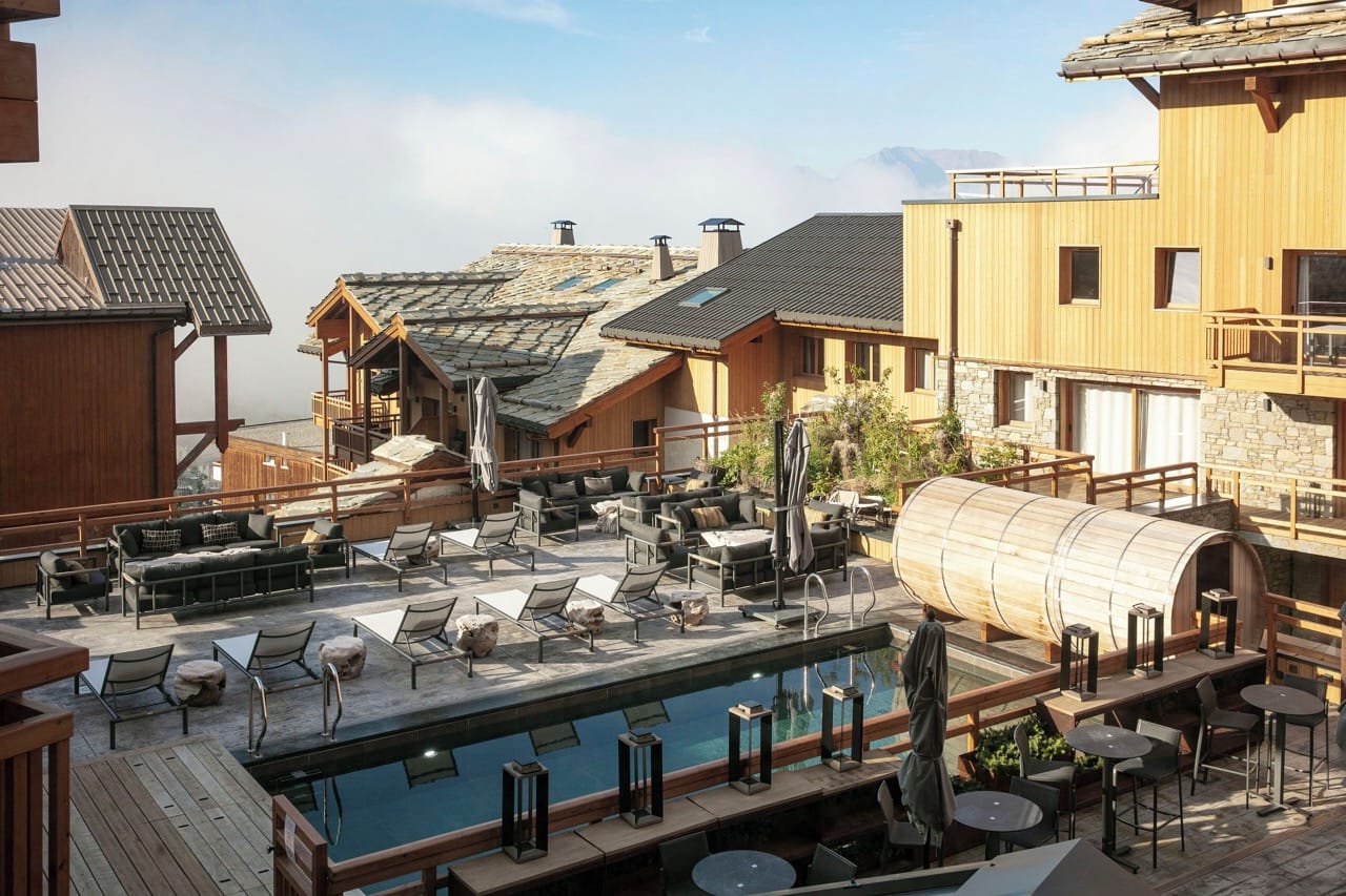 Outdoor rooftop pool at Grandes Rousses Hotel and Spa with tall buildings and sky in the background
