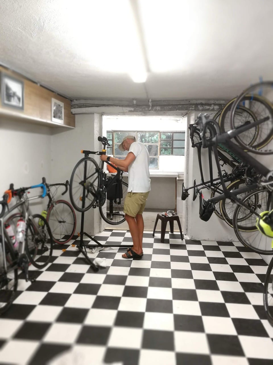 Bike storage with displayed bikes and checkerboard flooring inside Sport'Hotel-Aparthotel de Milan