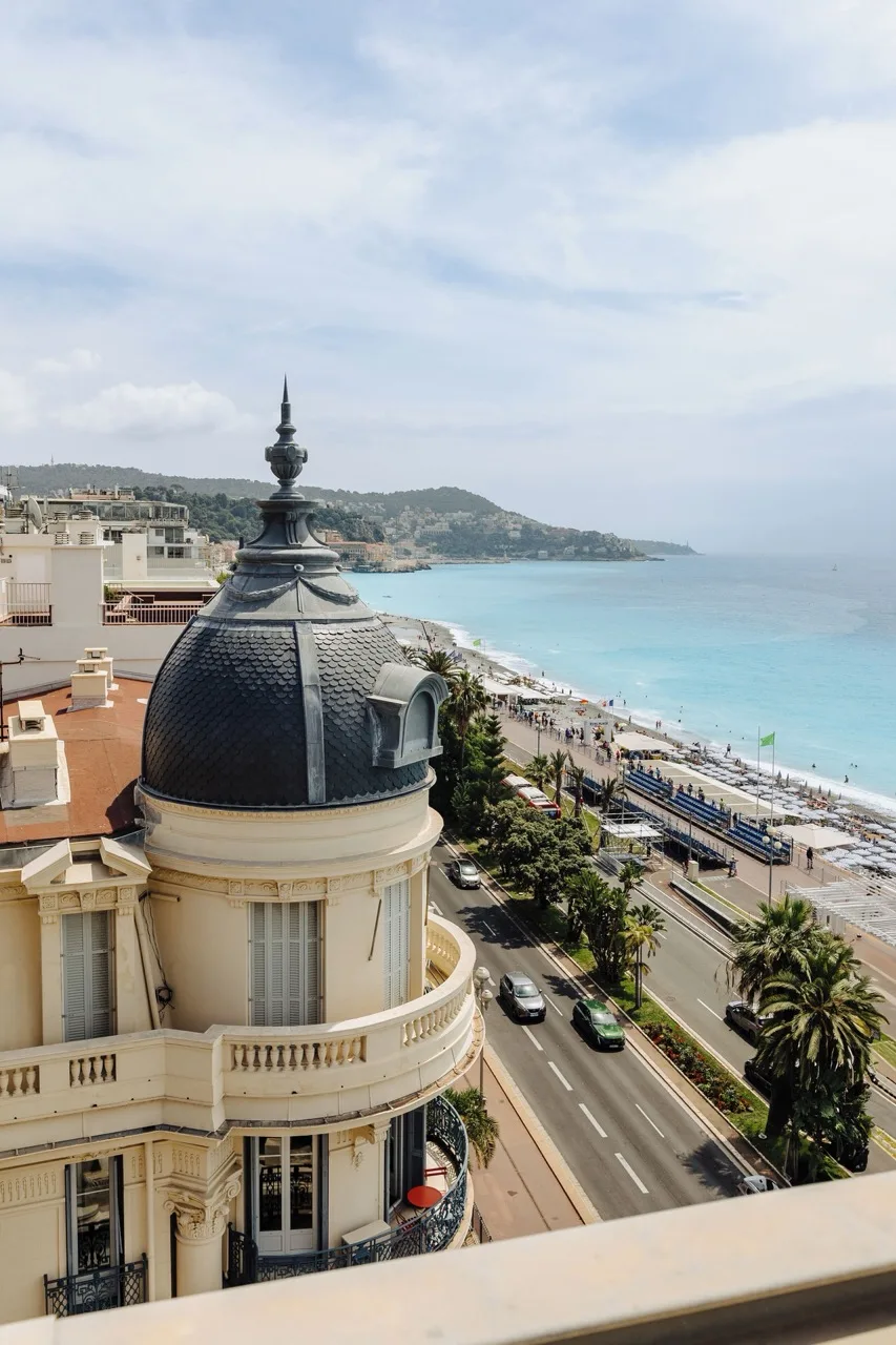 View from the hotel showing nearby traditional buildings, road, and ocean in the distance