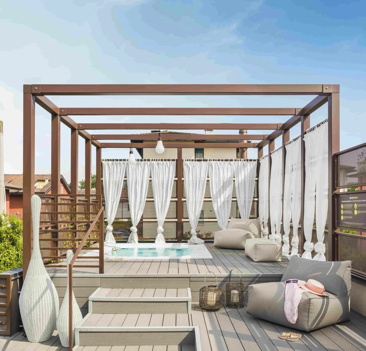 Jacuzzi centered in roofless frame with paneled floor and flowing curtains