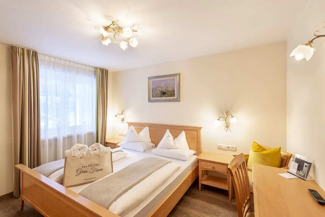 Bedroom at Hotel Gran Fanes with polka dot floor, wooden ceiling, and white walls with wood accents