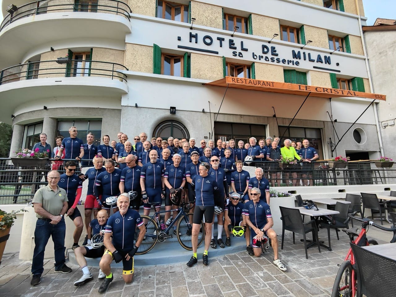 Exterior of Sport'Hotel-Aparthotel de Milan in Le Bourg-dʼOisans with cyclists posing in front