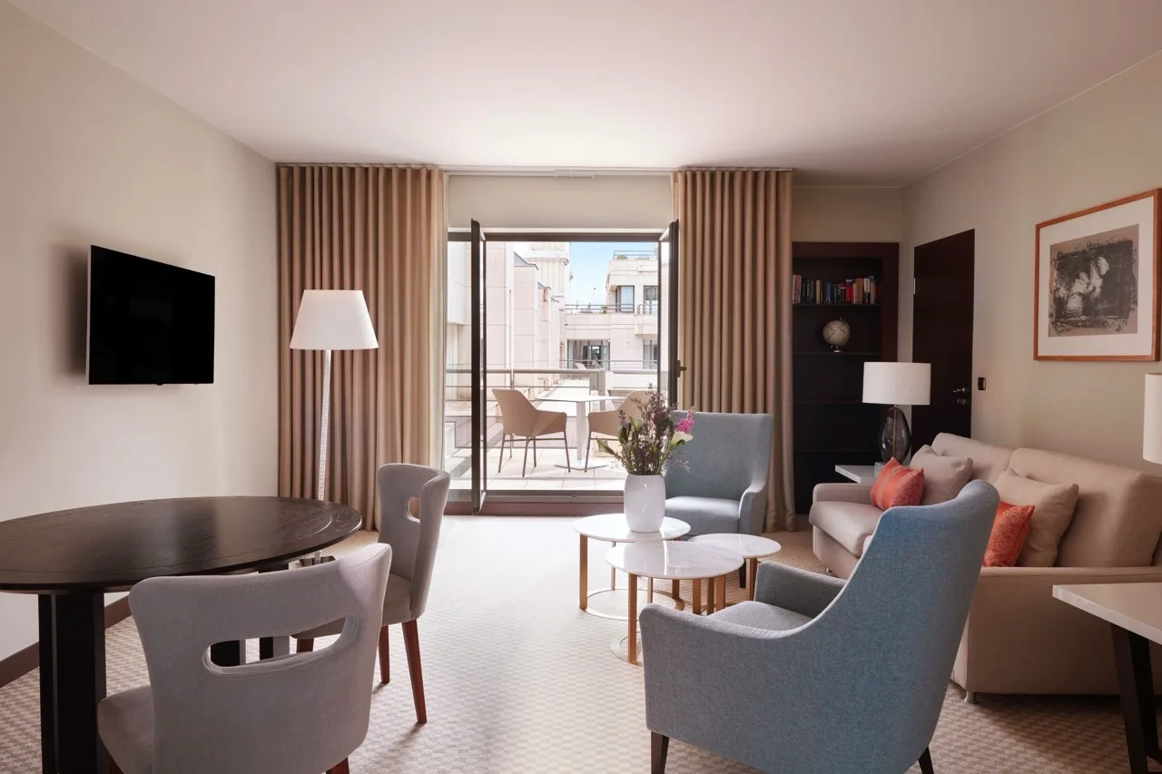 Suite at Hyatt Regency Nice Palais de la Méditerranée with mini dining table, small sofas, and balcony view