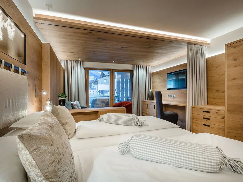 Bedroom at Hotel La Majun in La Villa with wood walls, ceilings, and white beds