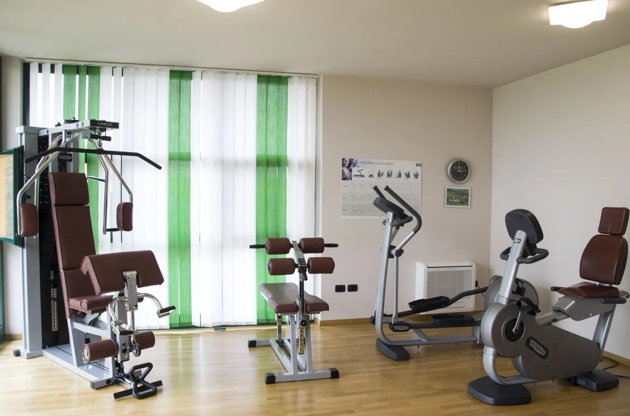Gym at Lo Scoiattolo Piedmont Bike Hotel with vinyl flooring and white walls in a bright workout space