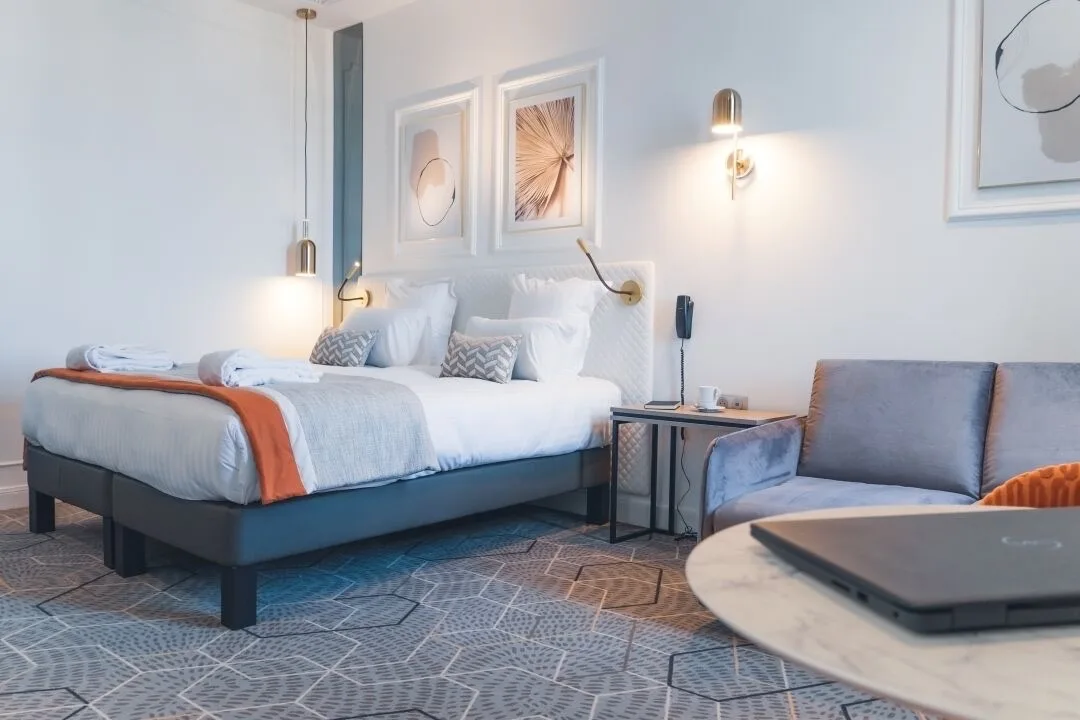 Bedroom at Hôtel D'Anjou Angers with white interior and patterned carpet design