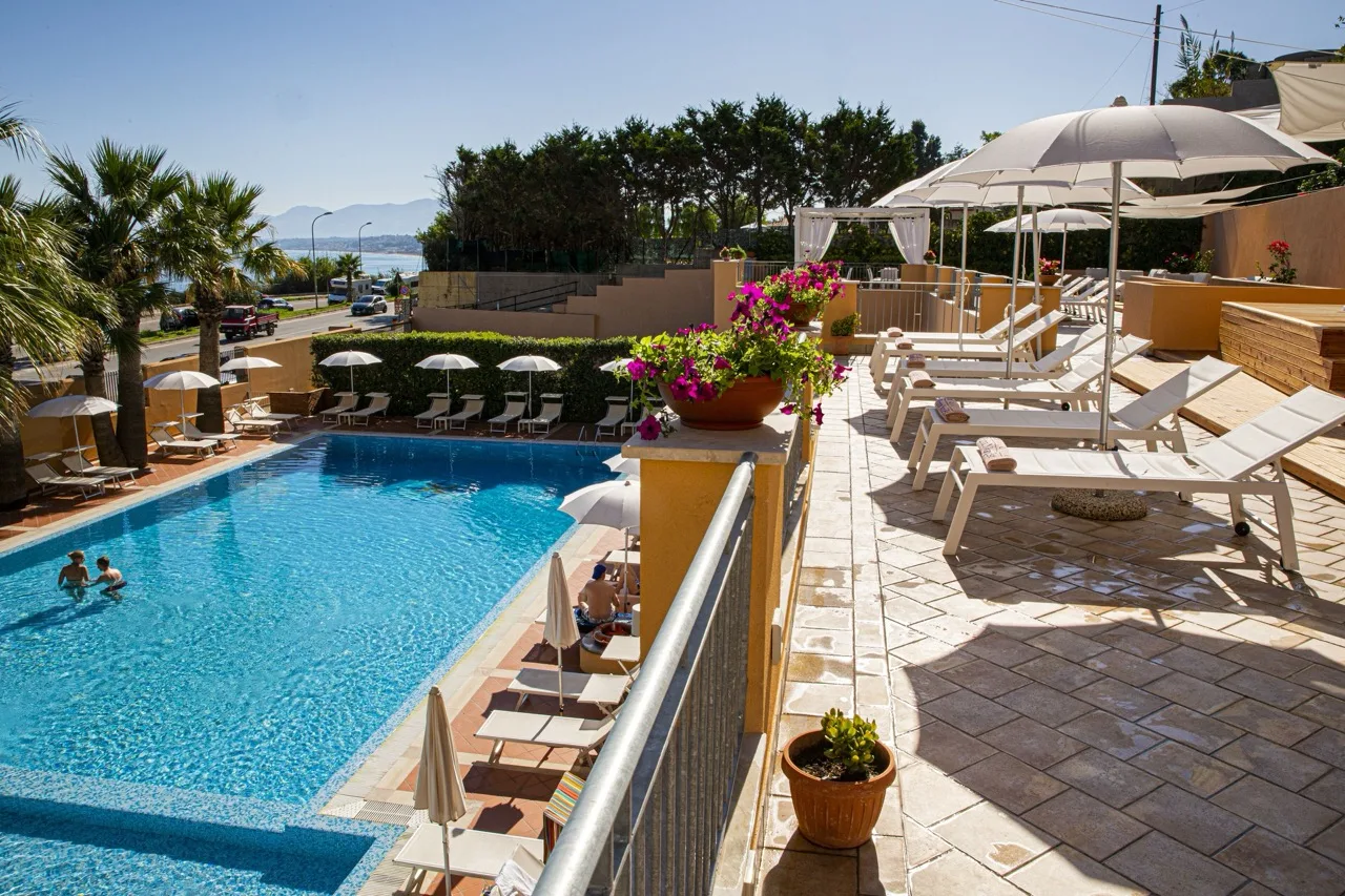 Outdoor pool at Hotel Punta Nord Est in Castellammare del Golfo with sea views and sun loungers