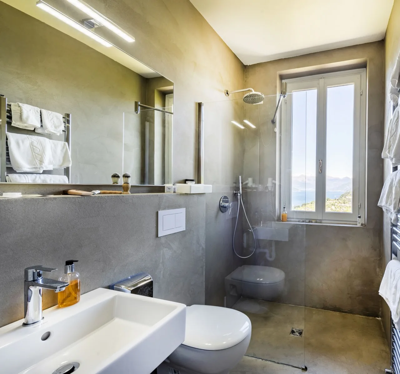 Bathroom at Hotel Il Perlo with light grey tiles, white basin, and toilet in a clean design