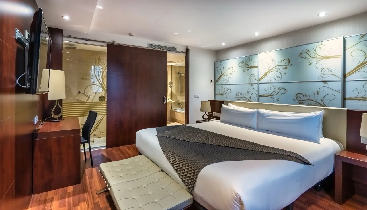 Large suite at Hotel Ultonia in Girona with oversized bed and living area in wood and white modern design
