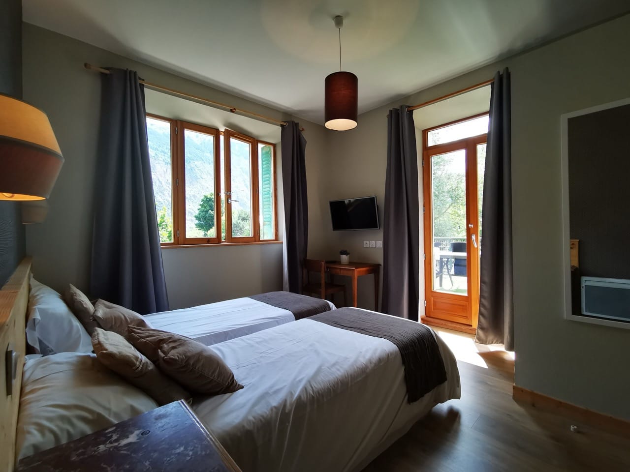 Bedroom at Sport'Hotel-Aparthotel de Milan with two single beds, balcony door, and windows letting in natural light