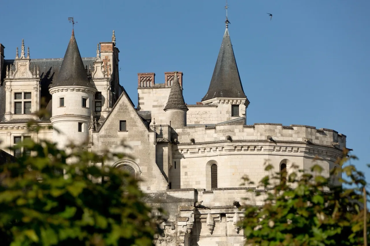 Exterior of Le Manoir Les Minimes Amboise showing elegant stone building with manicured gardens and blue sky