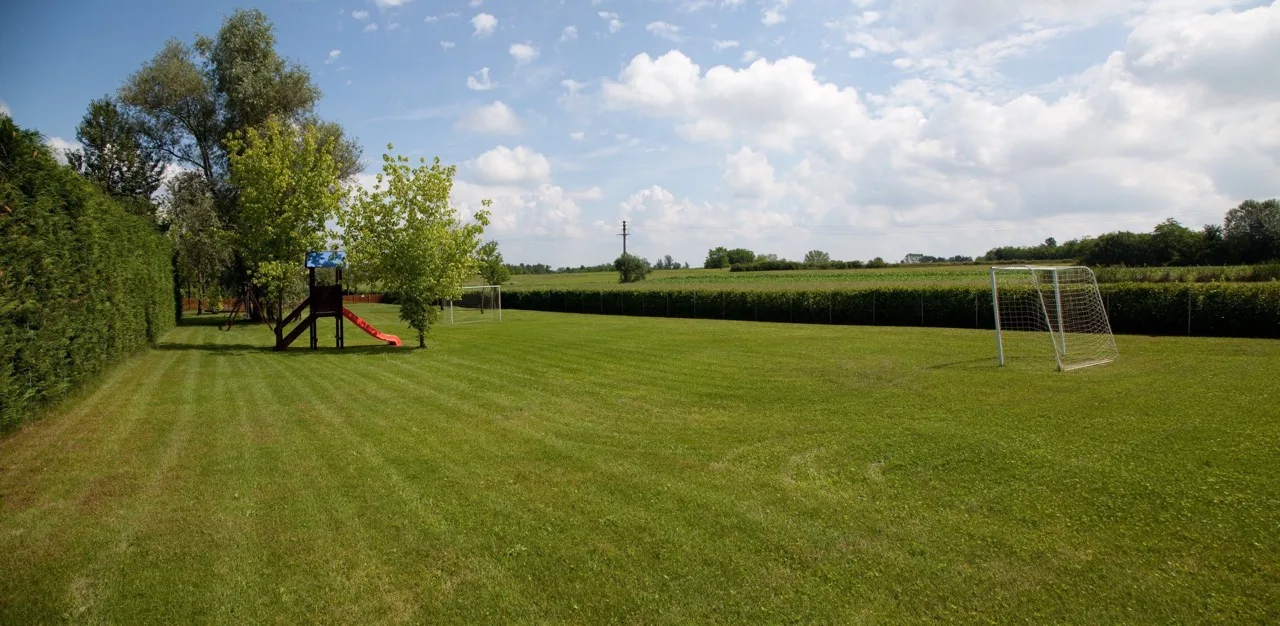 Wide green field at Lo Scoiattolo Piedmont Bike Hotel in Pralormo, surrounded by nature and open skies
