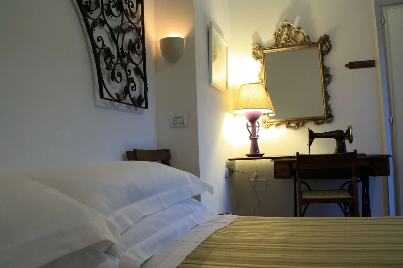 Bedroom at B&B Villa Giuliana in Arnesano with white interior, classic mirror, and traditional sewing machine