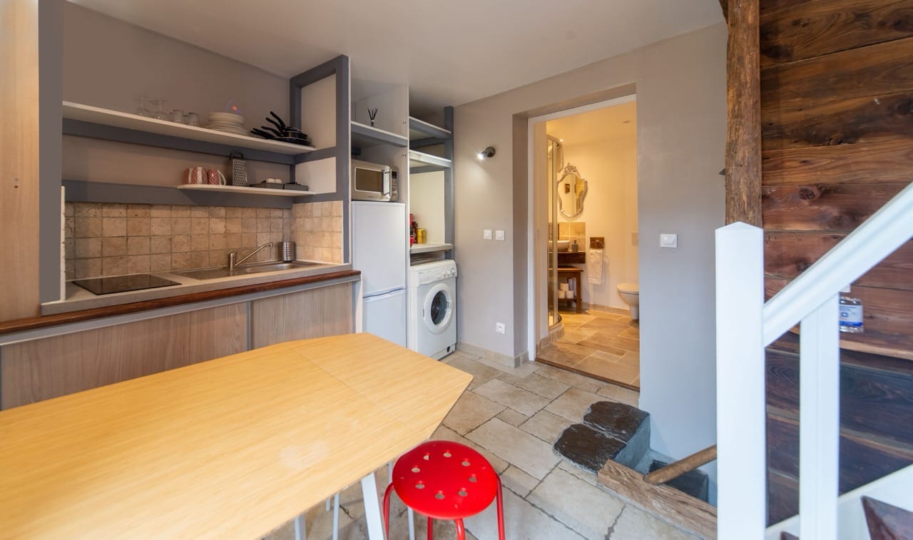 Inside Maison Caramel Landry guest house showing kitchen, glimpse of bathroom and staircase in the corner