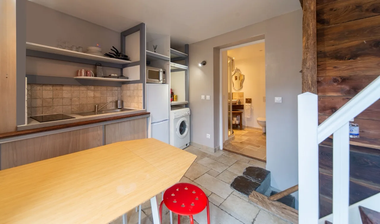Inside Maison Caramel Landry guest house showing kitchen, glimpse of bathroom and staircase in the corner