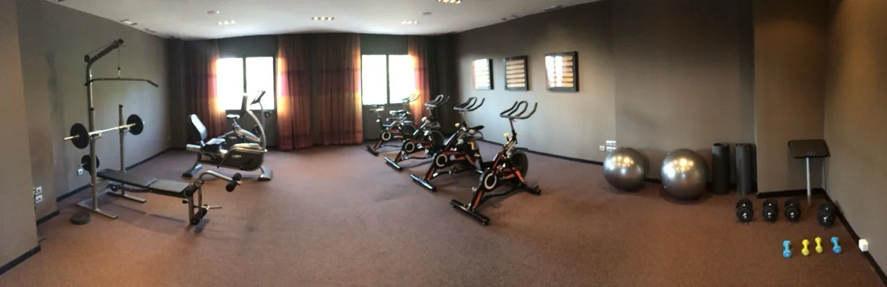 Gym at Hotel Palau de Bellavista Girona by URH with stationary bikes and free weights in a bright workout space