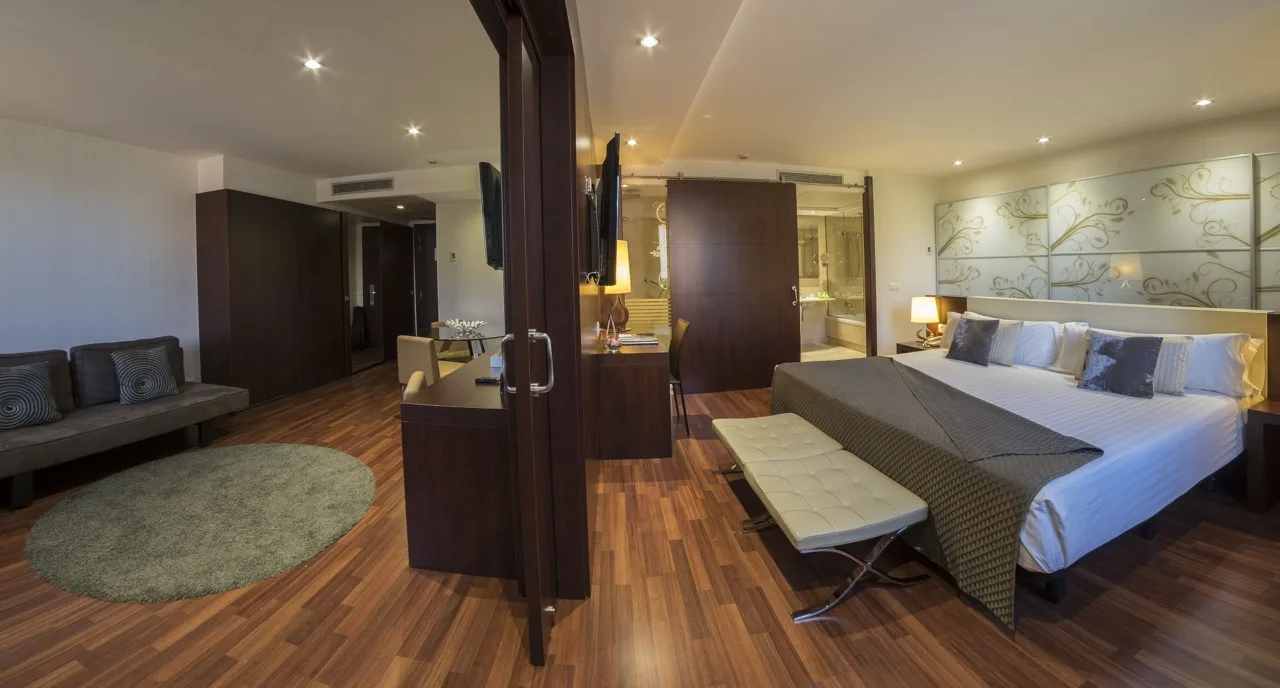Cozy suite at Hotel Ultonia in Girona with large bed and living room separated by wooden sliding door