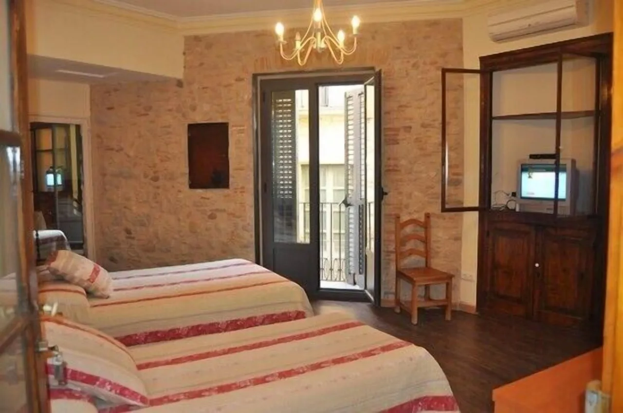 Traditional bedroom at Casa Cundaro in Girona with two single beds, rustic decor, and stone or white walls