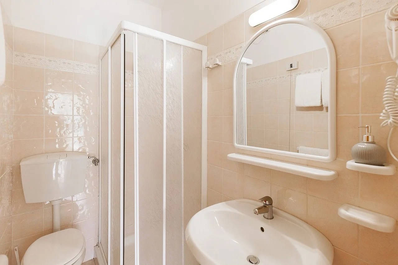 Minimalistic bathroom at Massa Vecchia with light tile walls and white furniture for a clean bright look