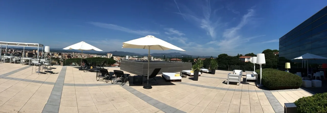 Outdoor view at Hotel Palau de Bellavista Girona by URH with chairs, umbrellas, and wide scenic surroundings