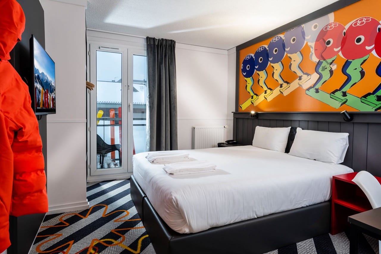 Bedroom at PopAlp in Alpe d'Huez with headboard mural white walls and black accent decor details