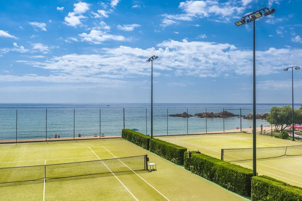 Tennis courts at Hotel Santa Marta in Lloret de Mar set in front of the sea with scenic coastal backdrop