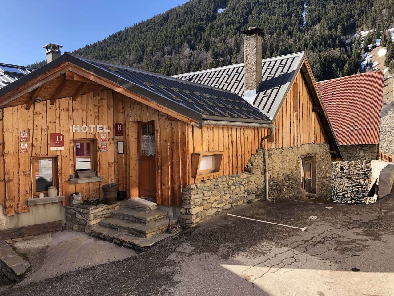 Exterior of Auberge de la Forêt in Auris with wooden facade and mountain backdrop