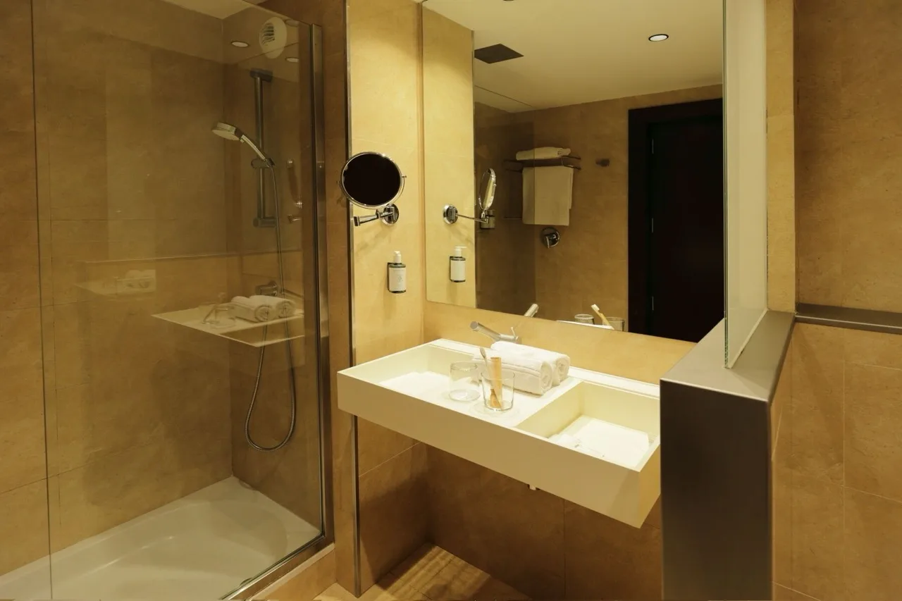 Bathroom at Hotel Ciutat de Girona with shower, white sink, and mirror in a clean, modern setting