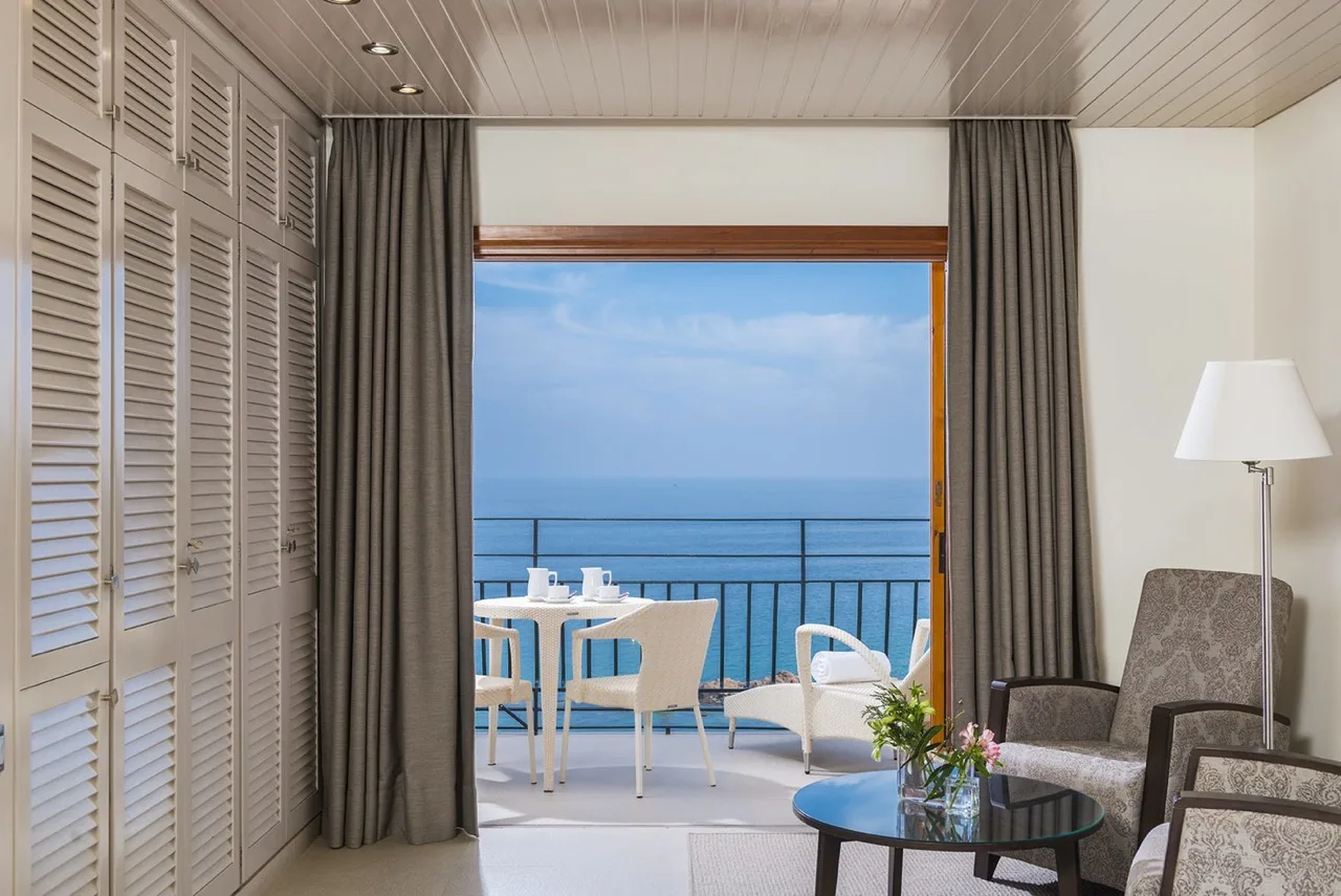 "Suite at Hotel Santa Marta with white and gray accents and a balcony offering a direct view of the sea