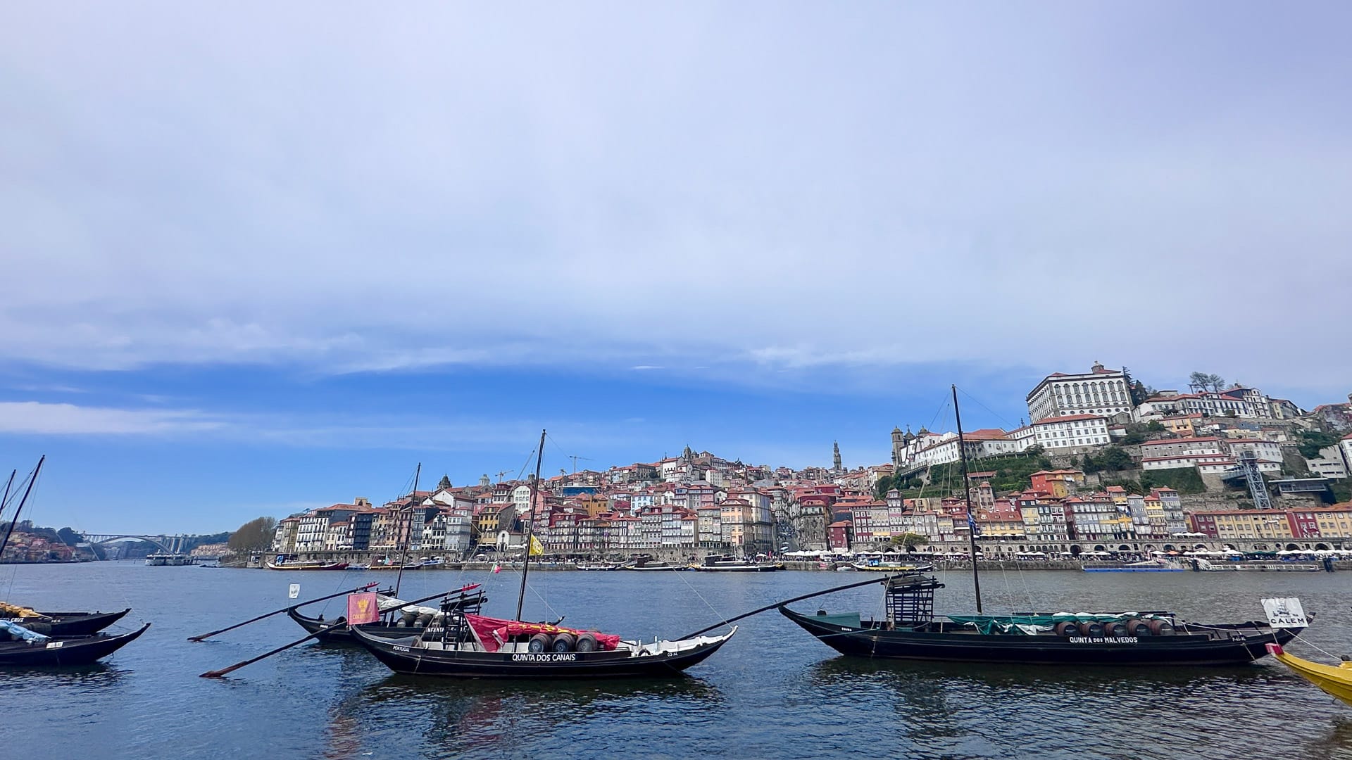 Boats on the river in Porto with hillside buildings in the background