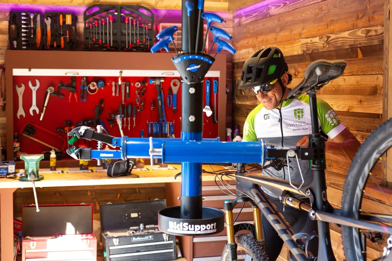 Bike repair area at Aktivhotel Santalucia, Lake Garda with tools in the background and a cyclist fixing his bike