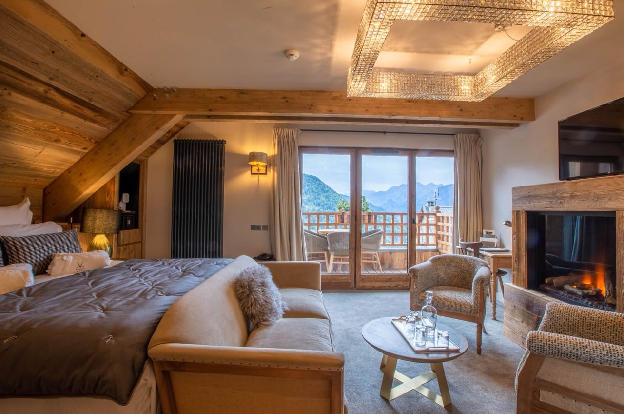 Bedroom at Hotel Le V de Vaujany with wooden interior white walls and warm lighting