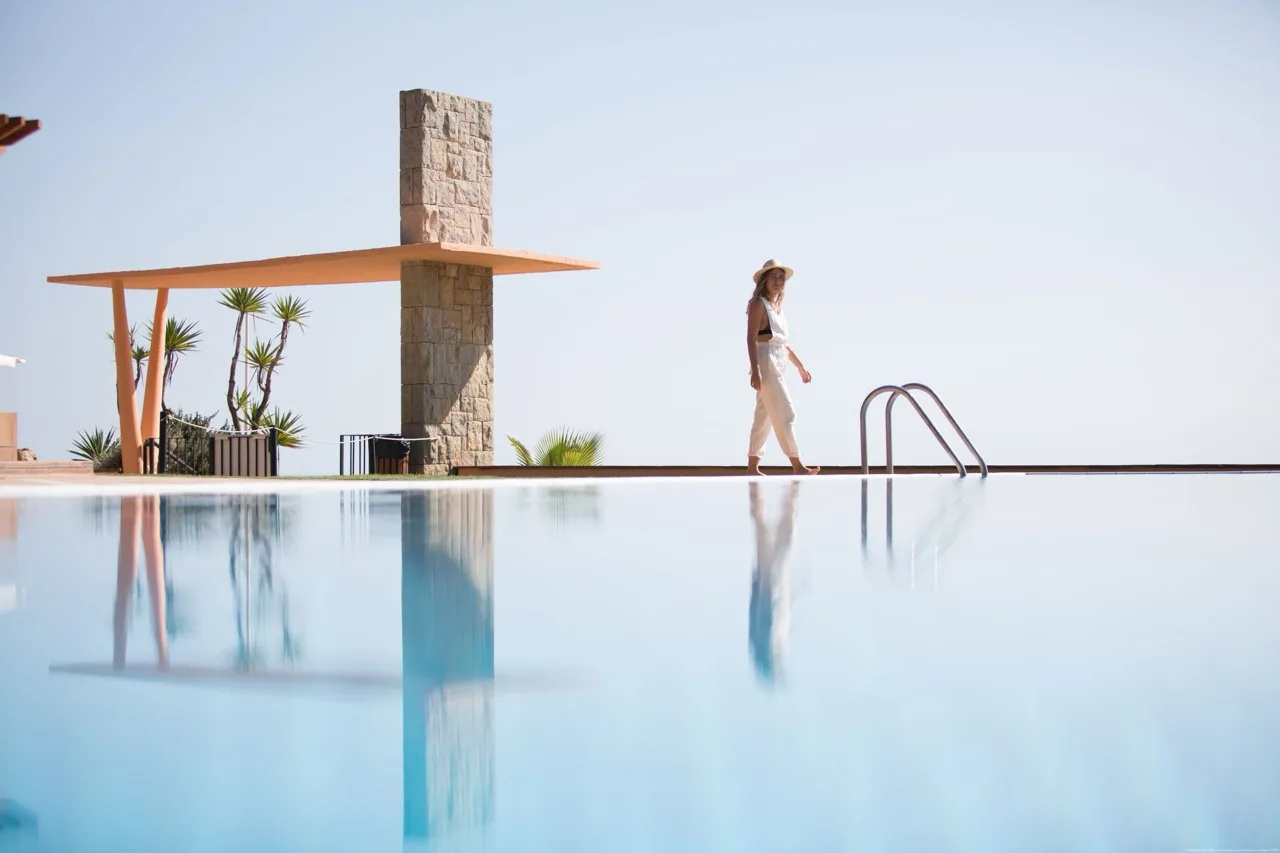 Outdoor pool at Hotel Santa Marta with a guest walking along the poolside