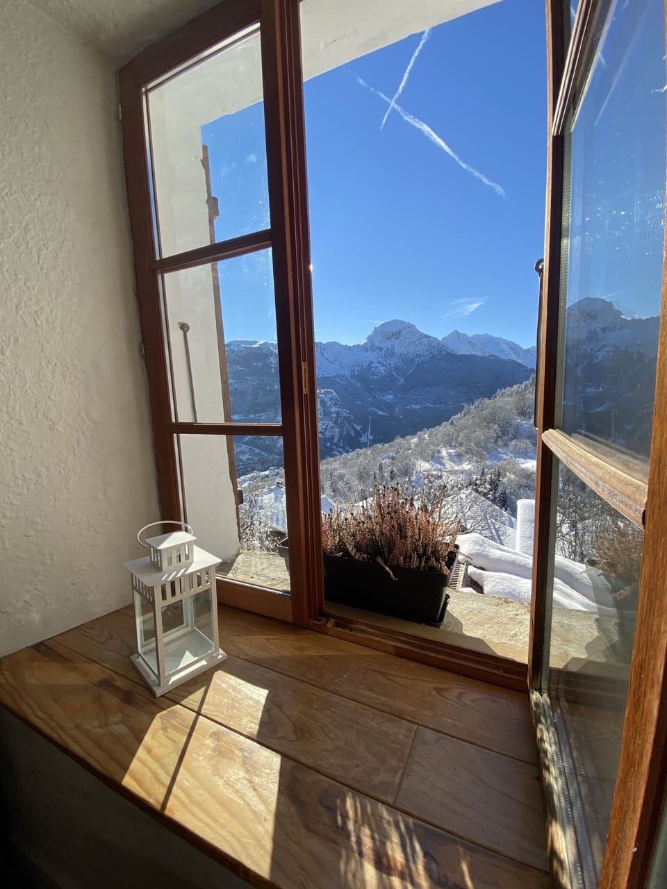 Traditional window at Auberge de la Forêt in Auris showing mountain views and rustic wooden frame