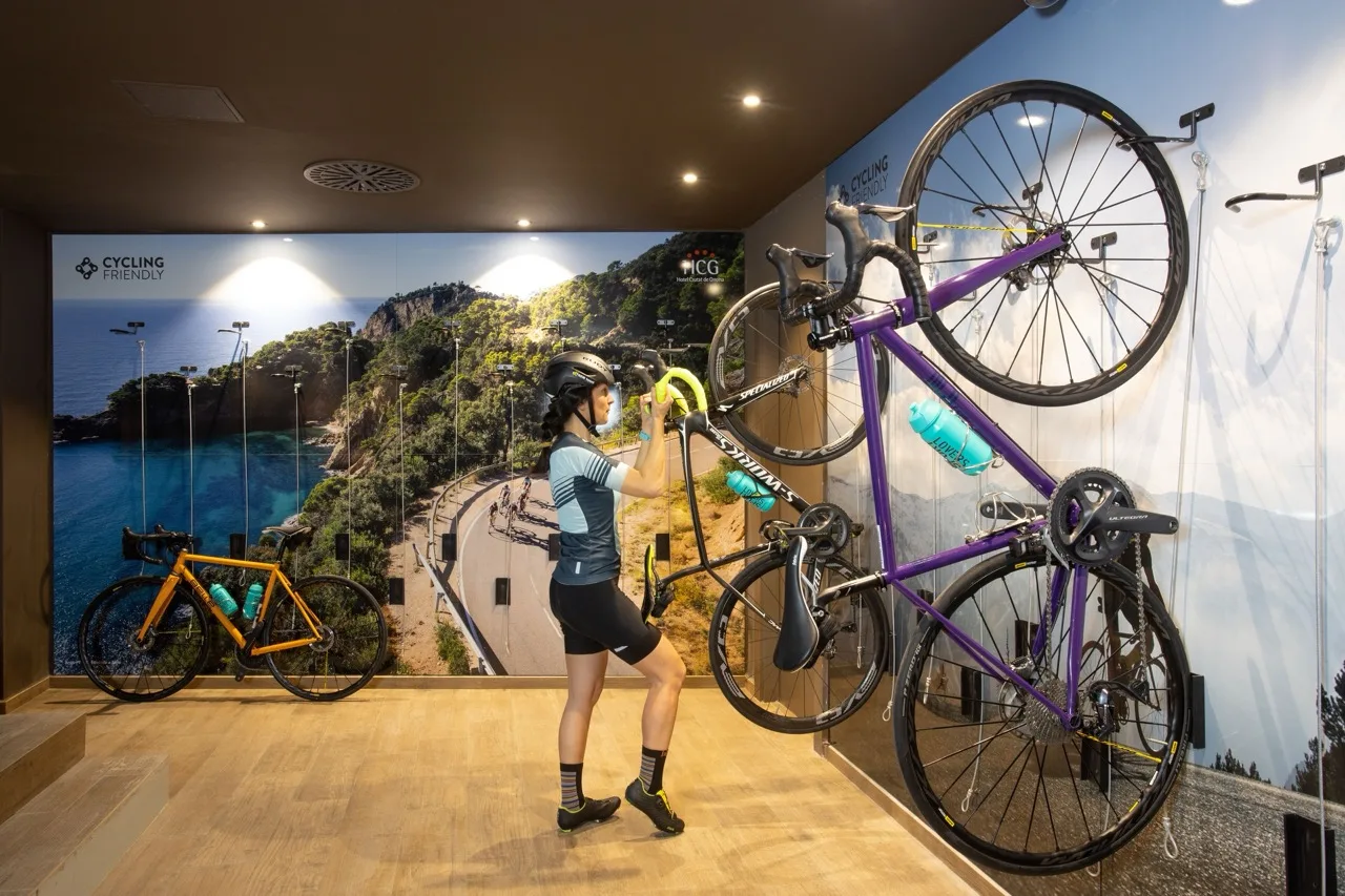 Bike storage area at Hotel Ciutat de Girona with a woman placing her bike inside the secure storage facility
