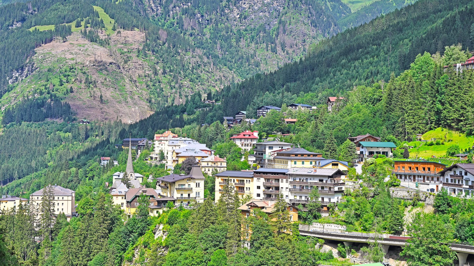 Bad Gastein photo showcasing its unique urban layout, historic Belle Époque hotels and traditional alpine houses built directly into the steep slopes of the Hohe Tauern mountains