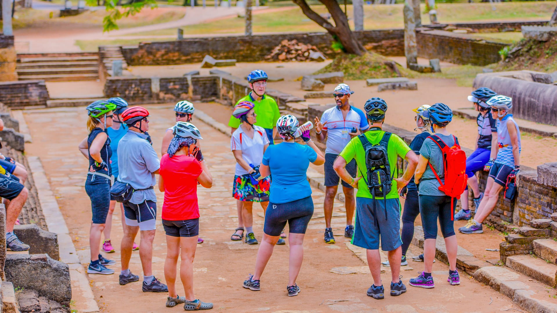 Cycling group listening to a local guide among ancient ruins in Sri Lanka’s cultural heartland