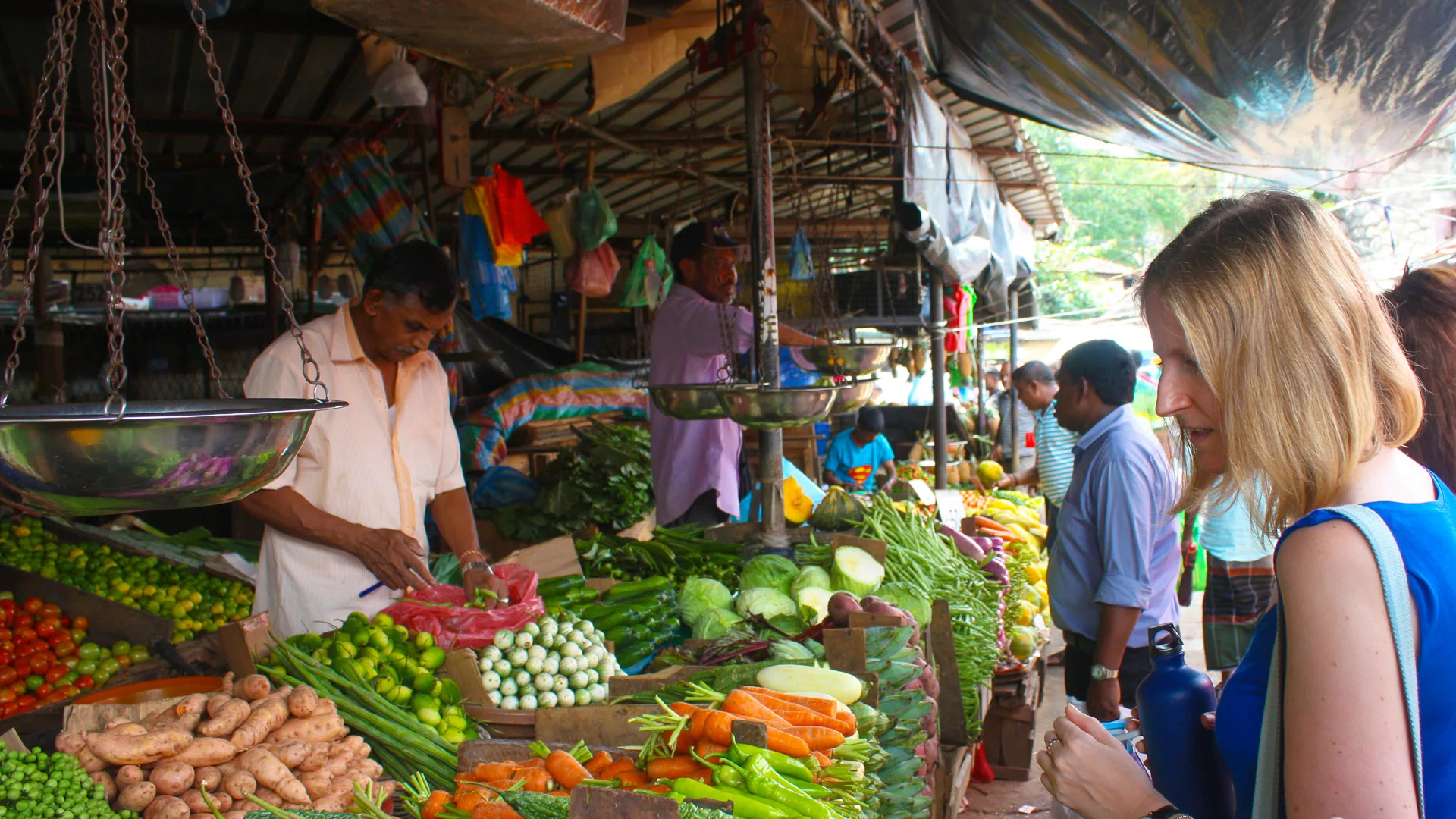 Woman browsing fresh vegetables at a colourful Sri Lankan market