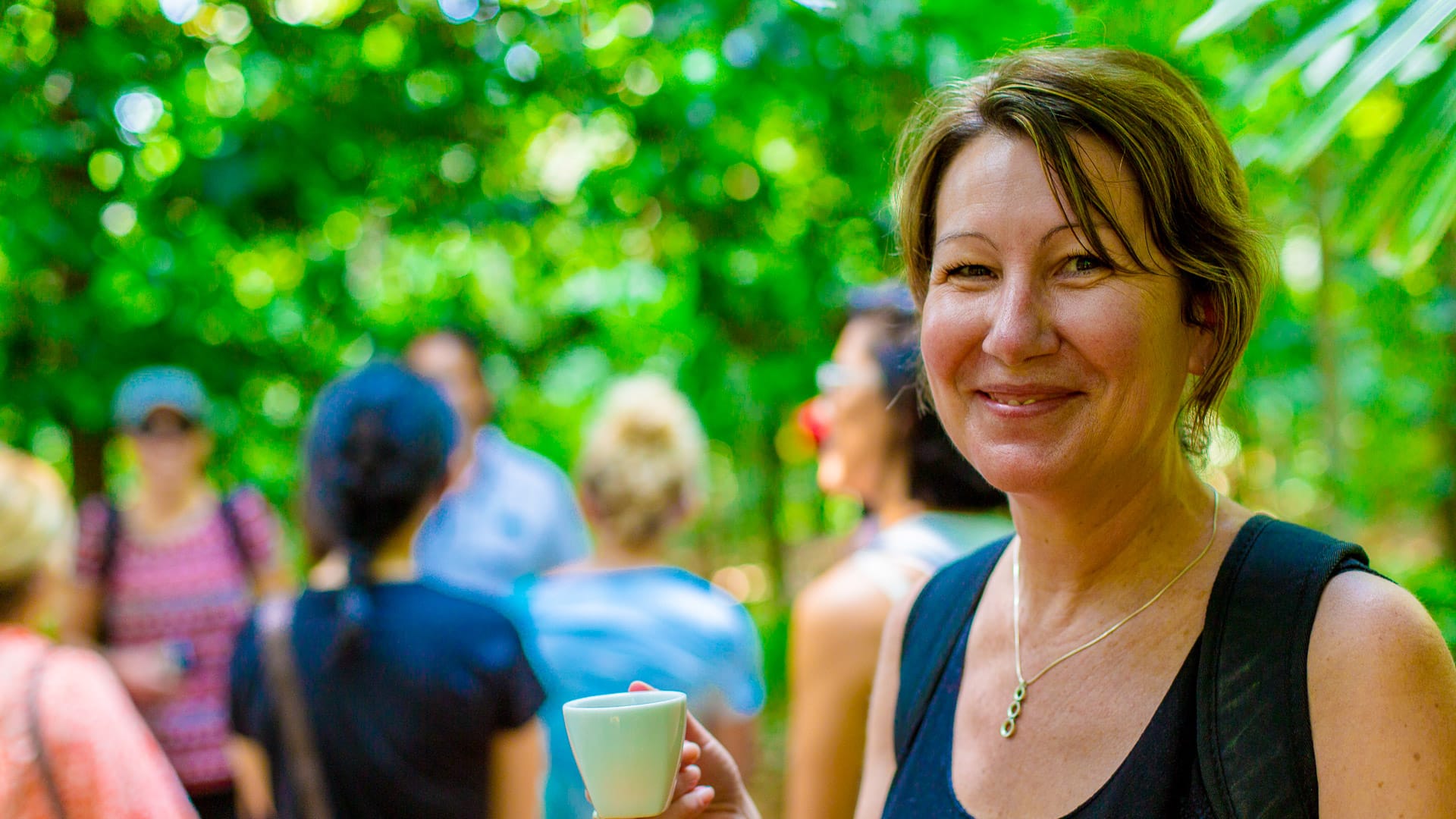 Smiling woman holding a cup during a tea tasting in Sri Lanka