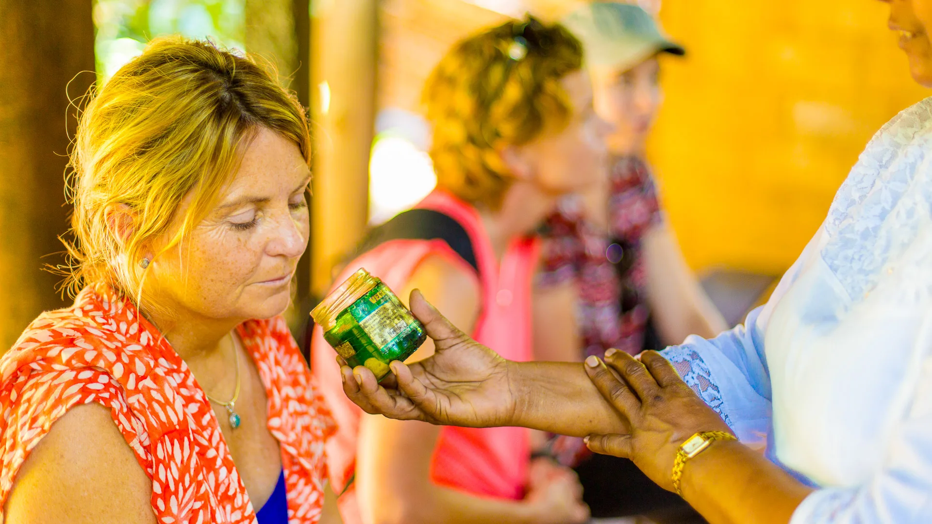 Woman being shown a herbal balm during a Sri Lankan local wellness demo