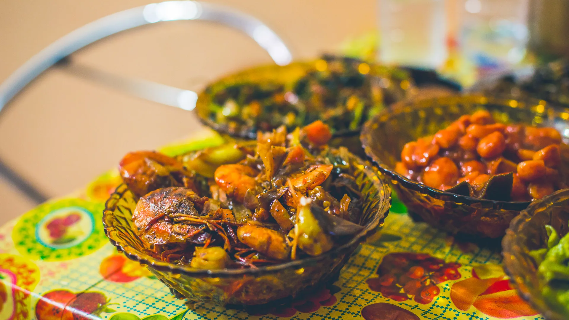 Close-up of bowls filled with colourful Sri Lankan curries on a floral table
