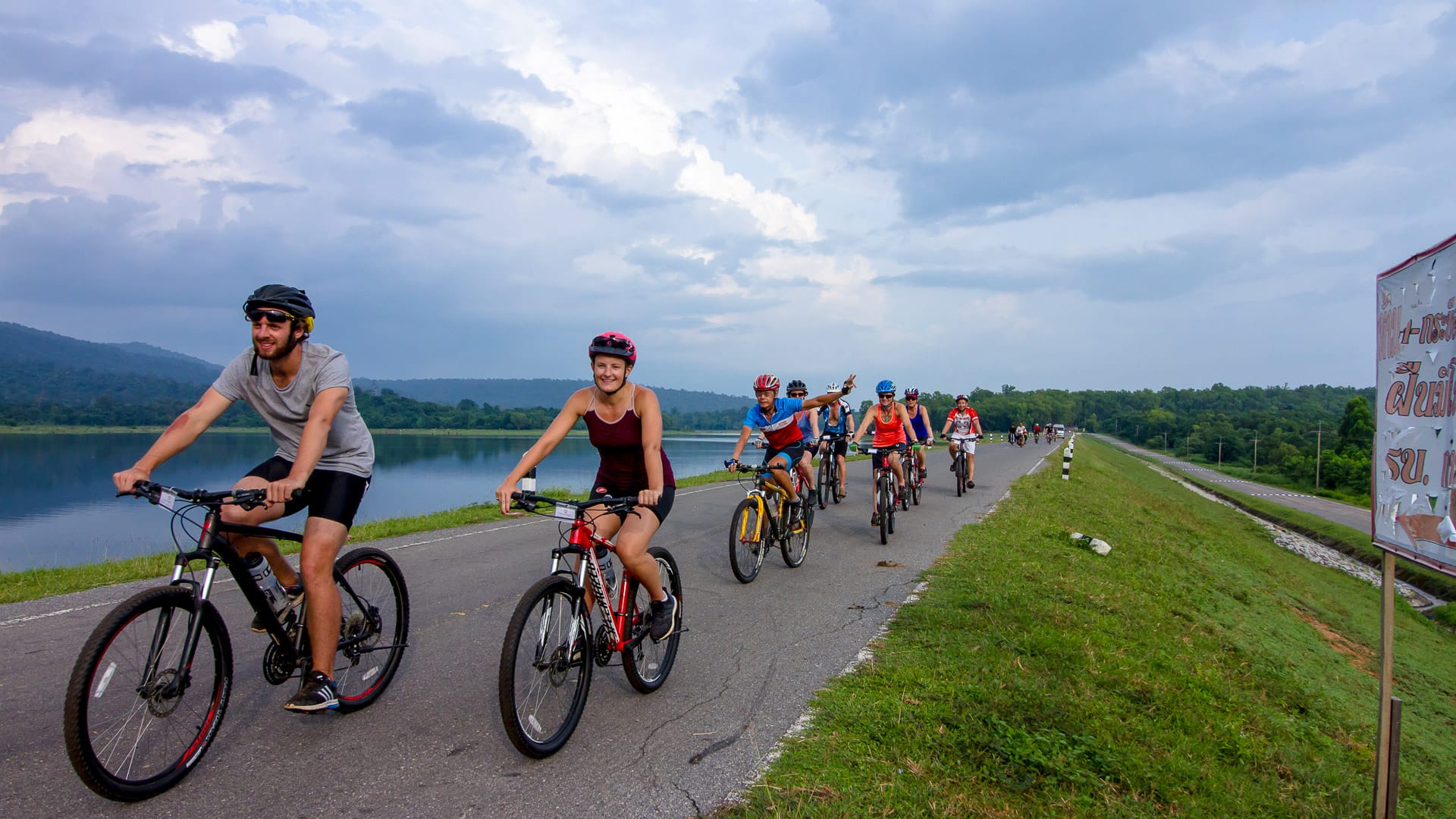 Group of cyclists riding along a lakeside road