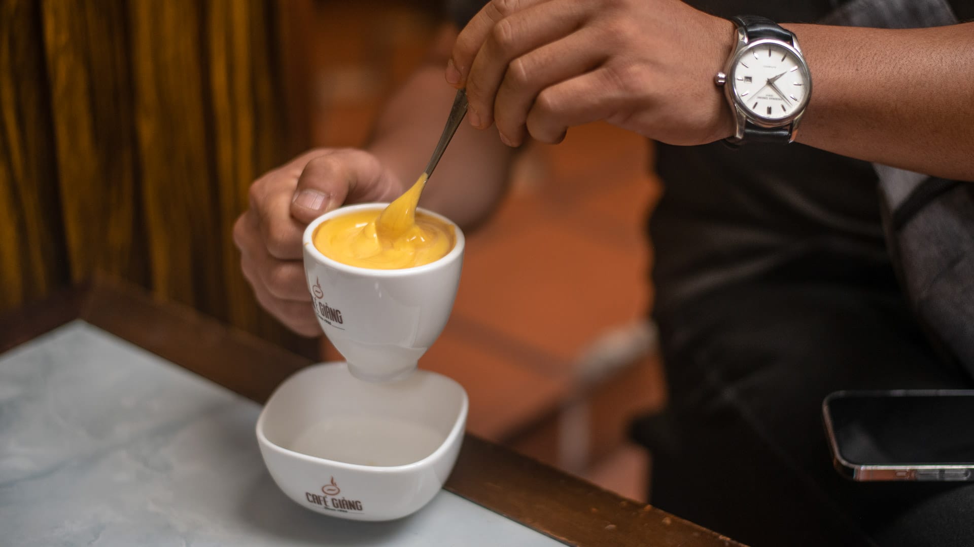 Traditional Vietnamese egg coffee being stirred in Hanoi