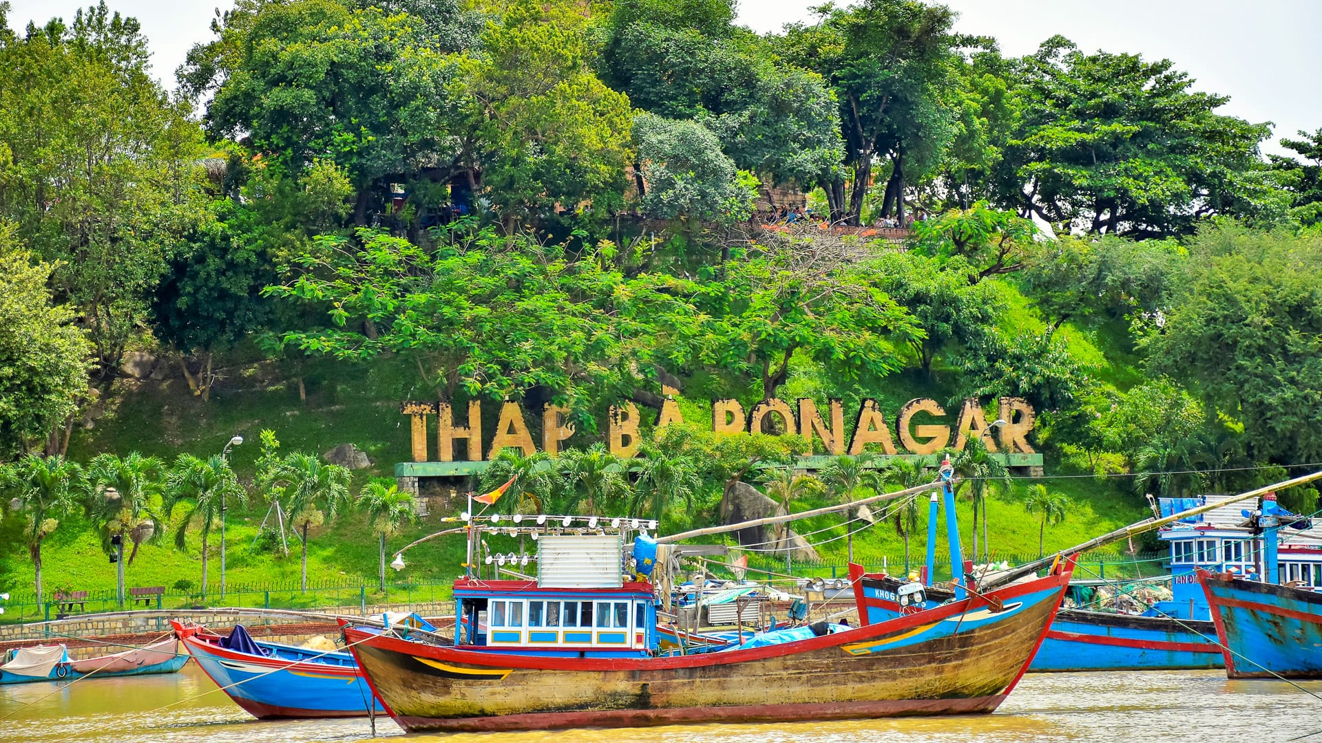 Colourful fishing boats on the river with Thap Ba Ponagar hill in Nha Trang